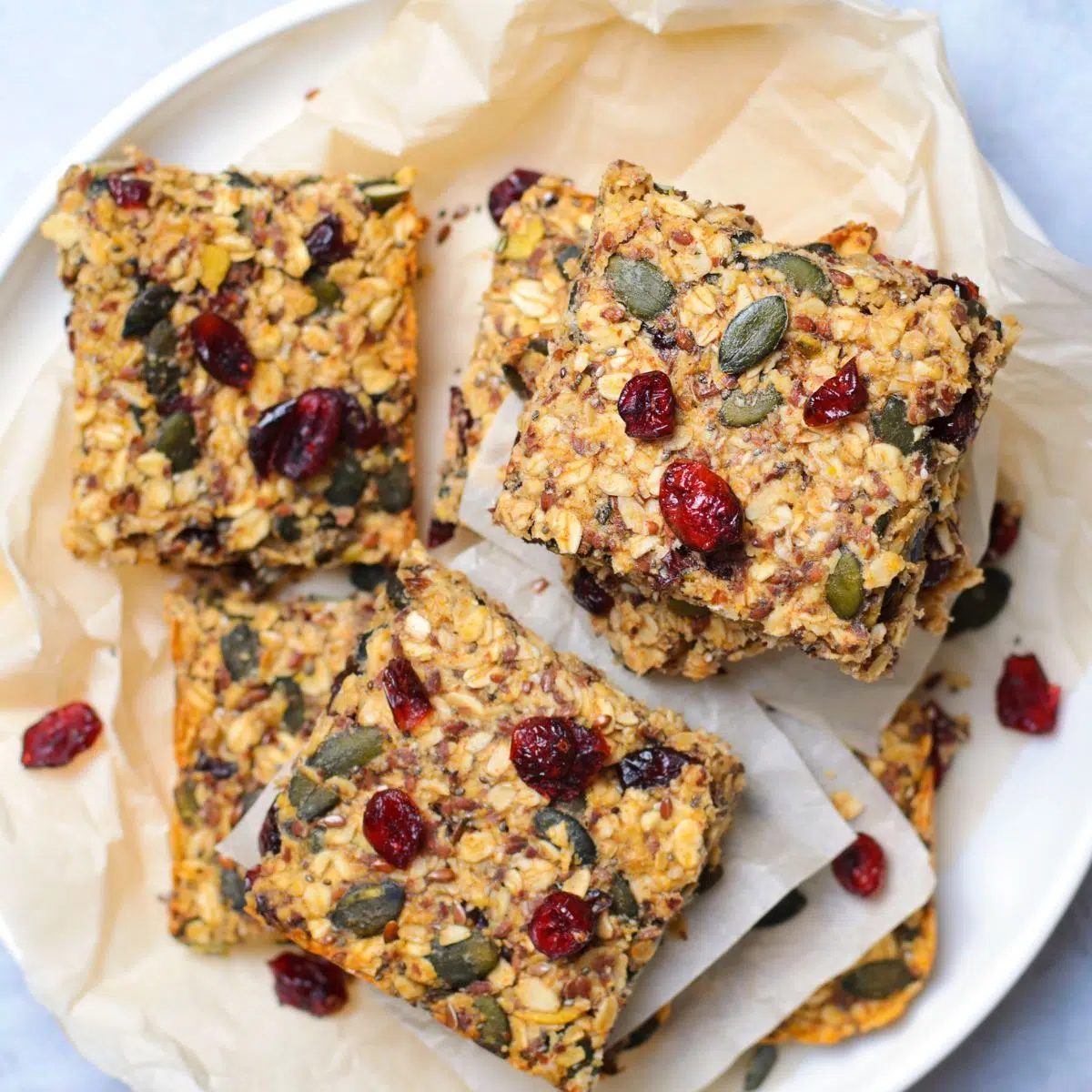 a white plate stacked with cut date sweetened pumpkin oat bars