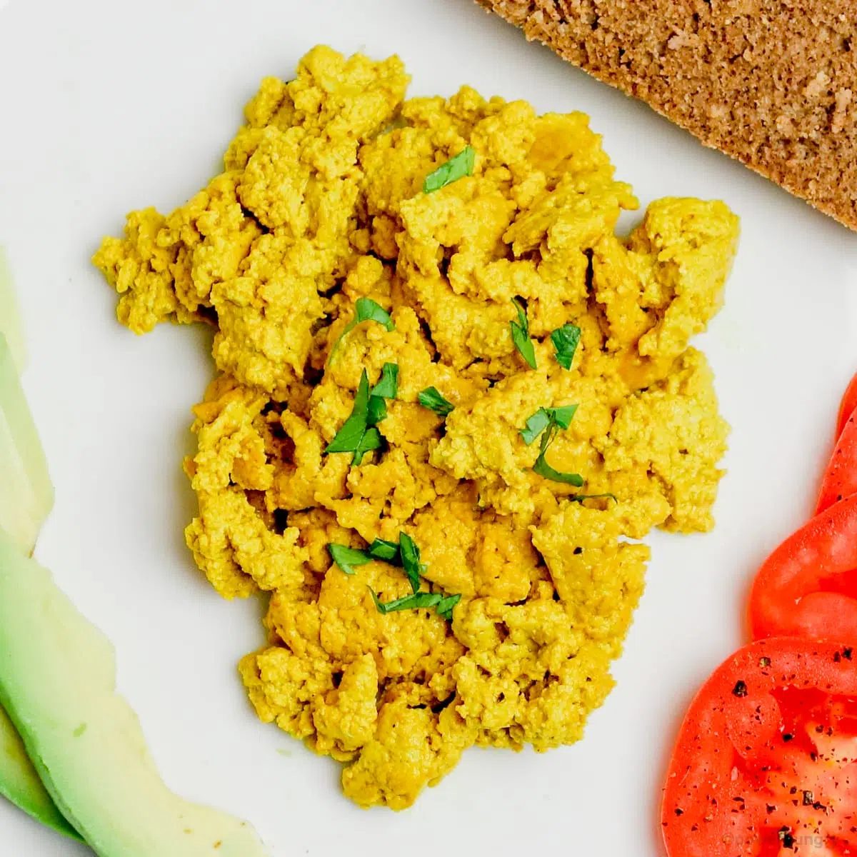 overhead shot of pumpkin scrambled eggs on a white plate