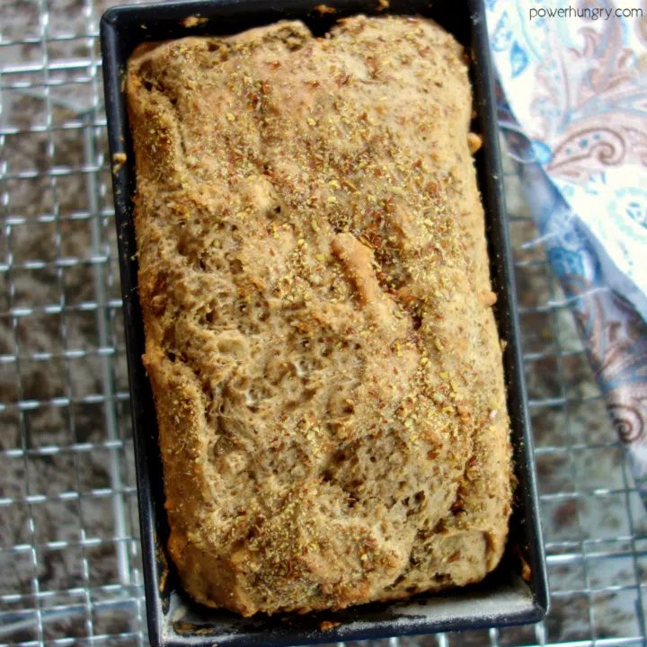 baked quinoa and almond soda bread in a metal baking tin, cooling on a wire cooling rack.