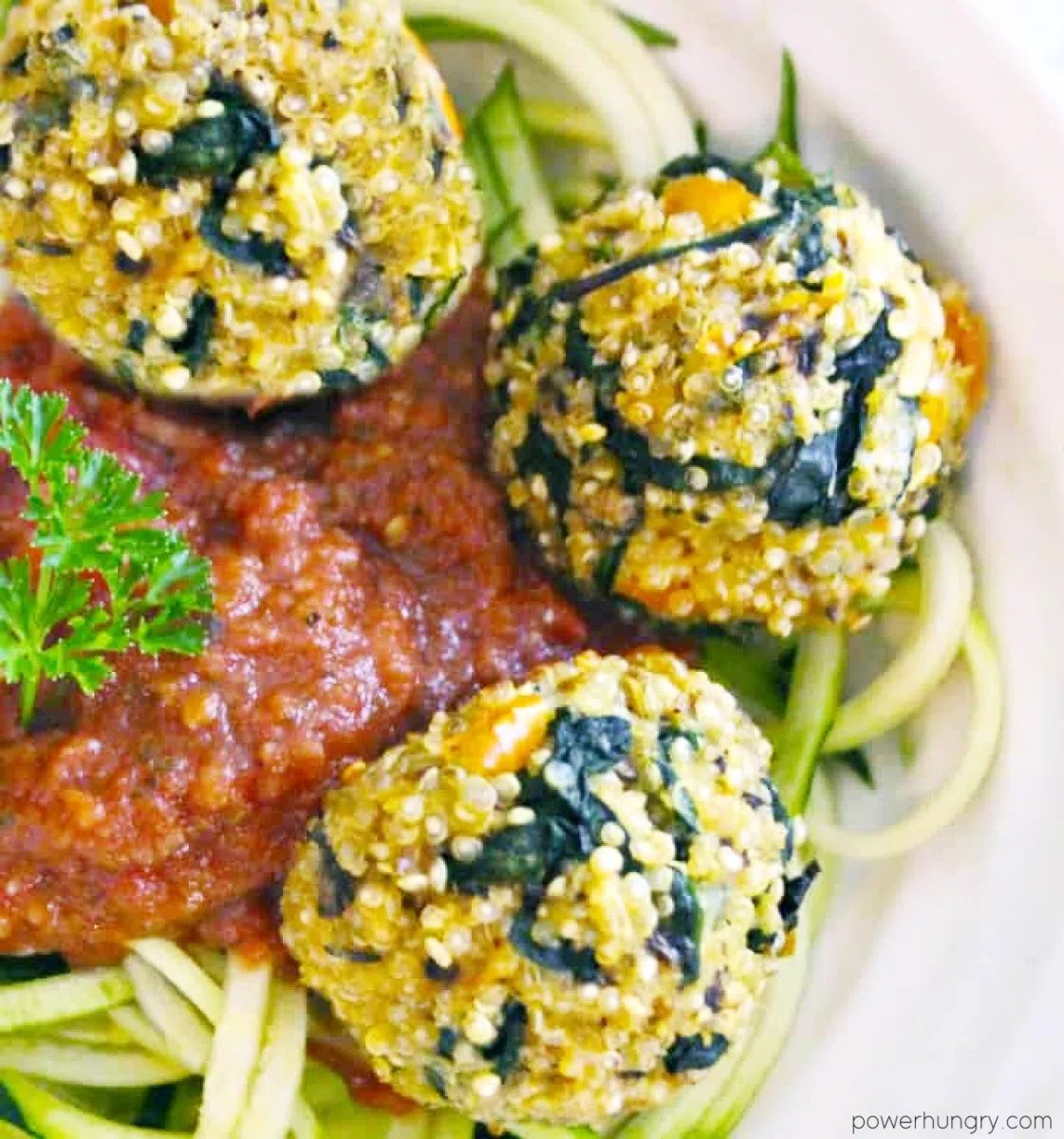 high protein quinoa kale meatballs on zucchini noodles in a white bowl
