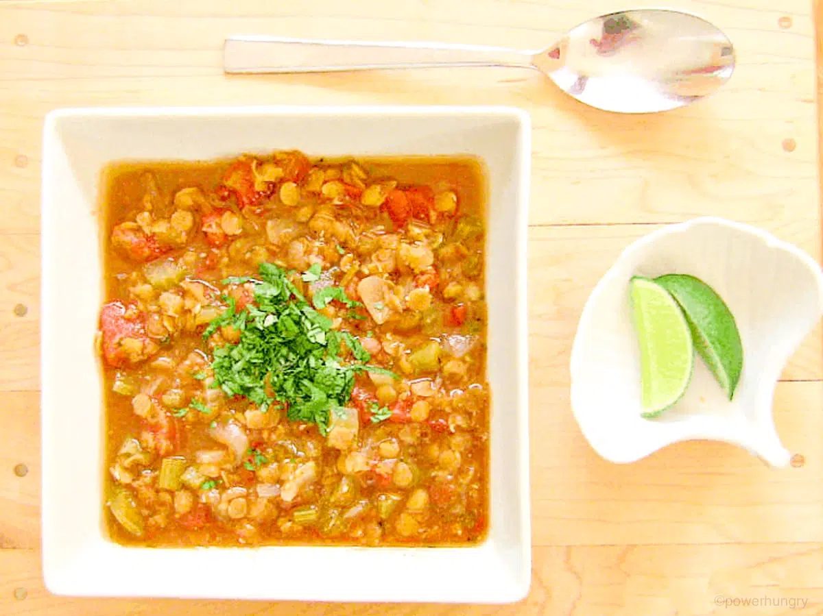 straightforward red lentil curry in a white square bowl atop a wooden cutting board