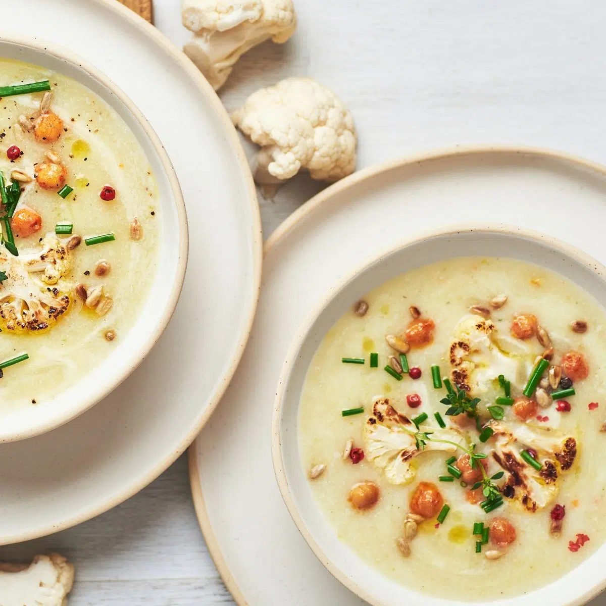 two bowls filled with vegan high protein roasted cauliflower soup