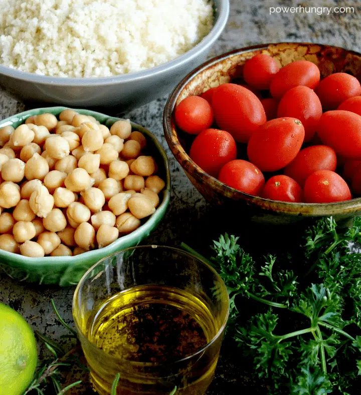 ingredients for chickpea tomato and cauliflower salad laid out on a baking sheet