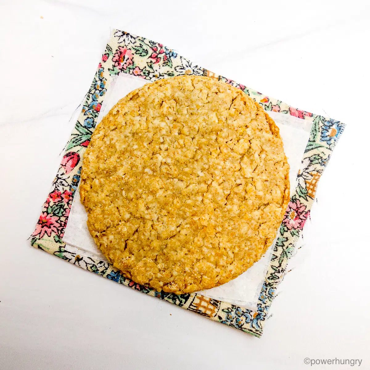 a single Scottish oatcake on a piece of parchment on a floral napkin