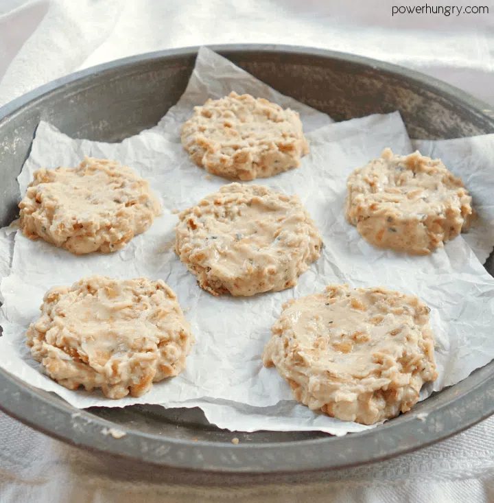 uncooked vegan sausage patties in an antique pie pan, atop parchment paper