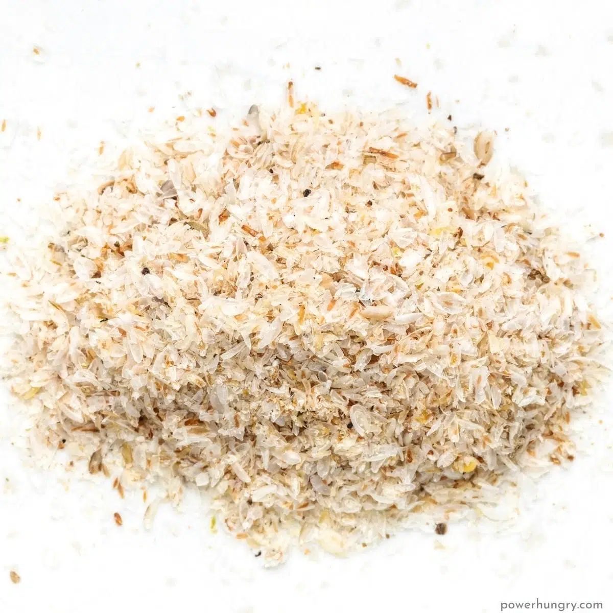 a pile of whole psyllium husks on a white background