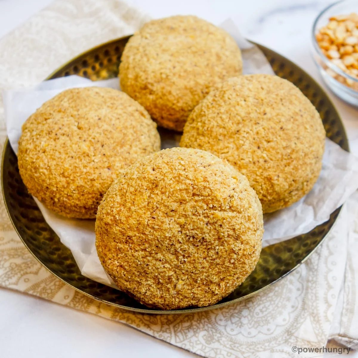 a copper bowl filled with split pea bread rolls
