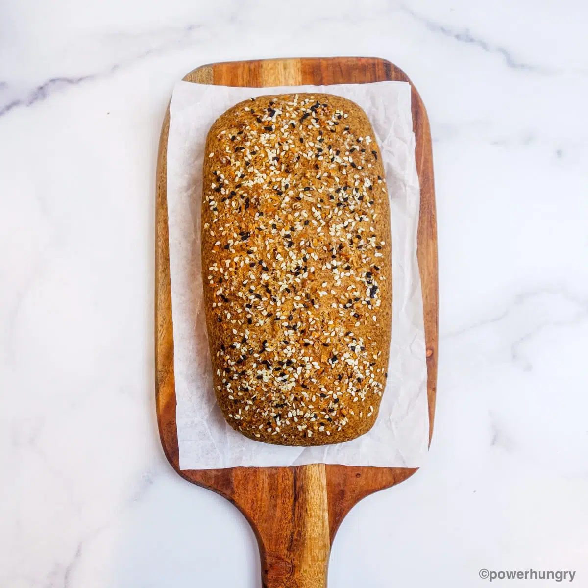 loaf of pea bread on a wooden cutting board