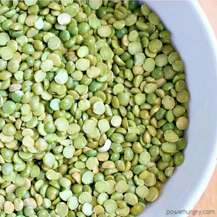 uncooked dry green split pes in a white bowl