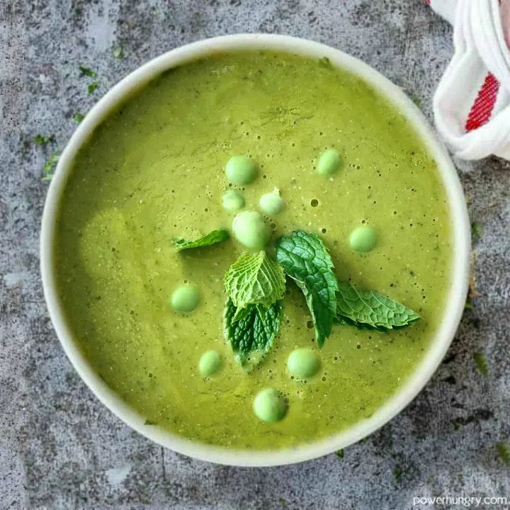 ovehead shot of green soup made with split pes and frozen green peas in a white bowl