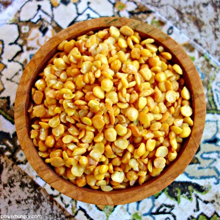 a wooden bowl filled with baked crispy split peas