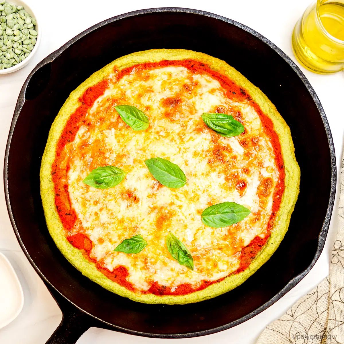 split pea pizza crust made with three ingredients, in a cast iron skillet