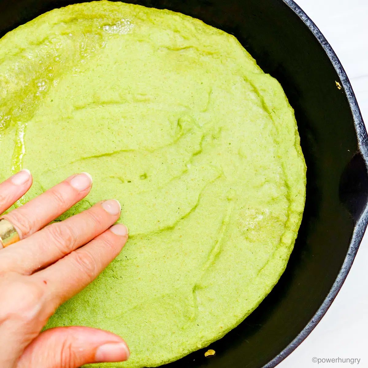 split pea pizza crust in cast iron skillet after first bake