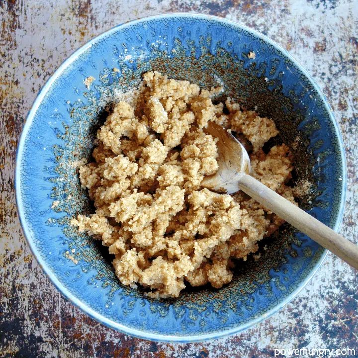 Decorative blue pottery bowl filled with almond flour crumb mixture