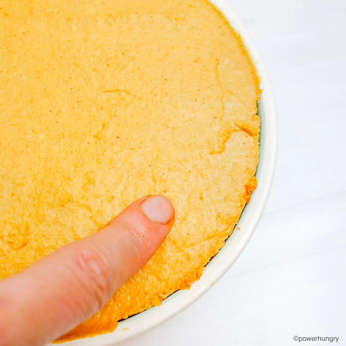 testing if cheese is set with an index finger