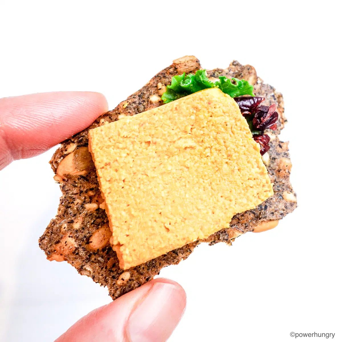 a slice of sunflower seed cheddar cheese on a cracker