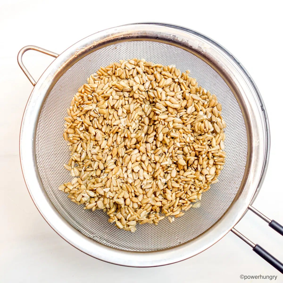 gained soaked sunflower seed kernels in a mesh sieve