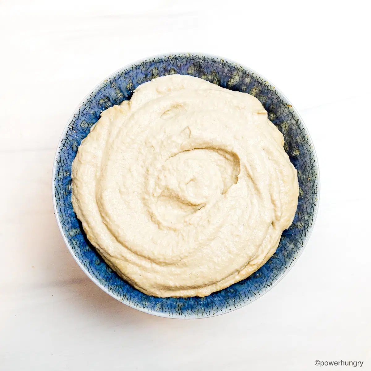 blue bowl filled with chilled sunflower seed whipped cream