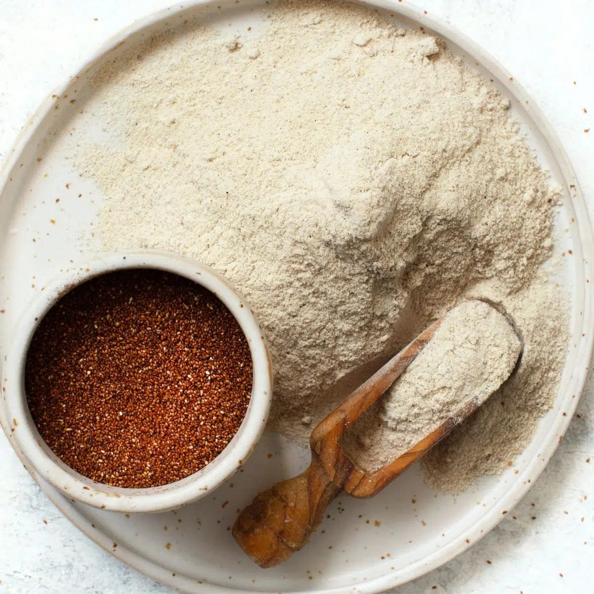 teff grain and flour on a white plate