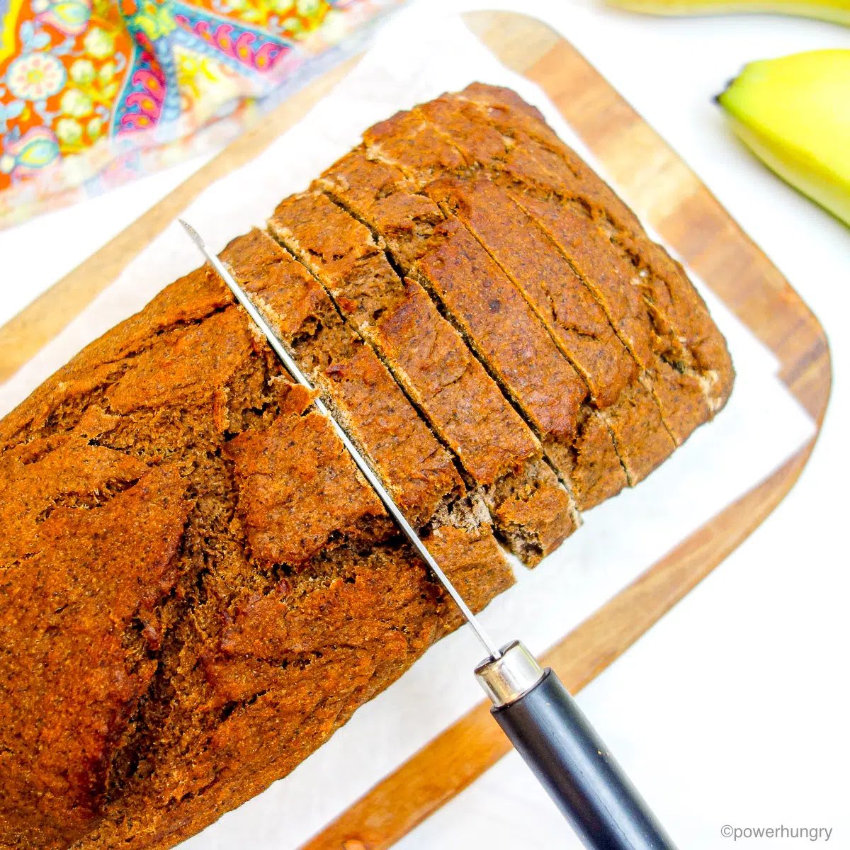 teff banana bread getting sliced on a cutting board