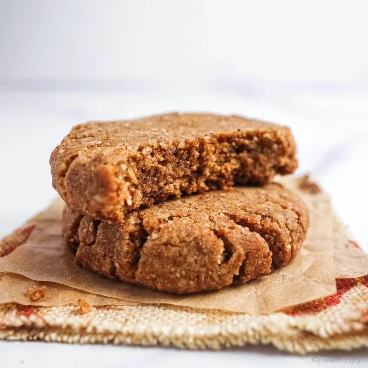 a stack of two ginger tiger nut cookies on a floral napkin