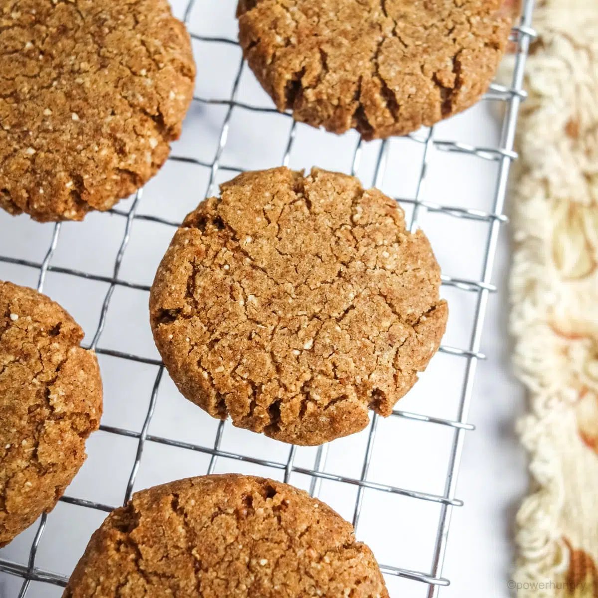 tiger nut ginger cookies cooling on a wire cooling rack with a pale coral napkin alongside