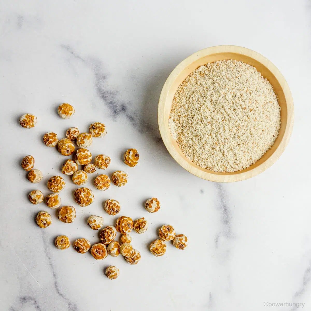 overhead shot of whole tiger nuts and a wood bowl full of tiger nut flour