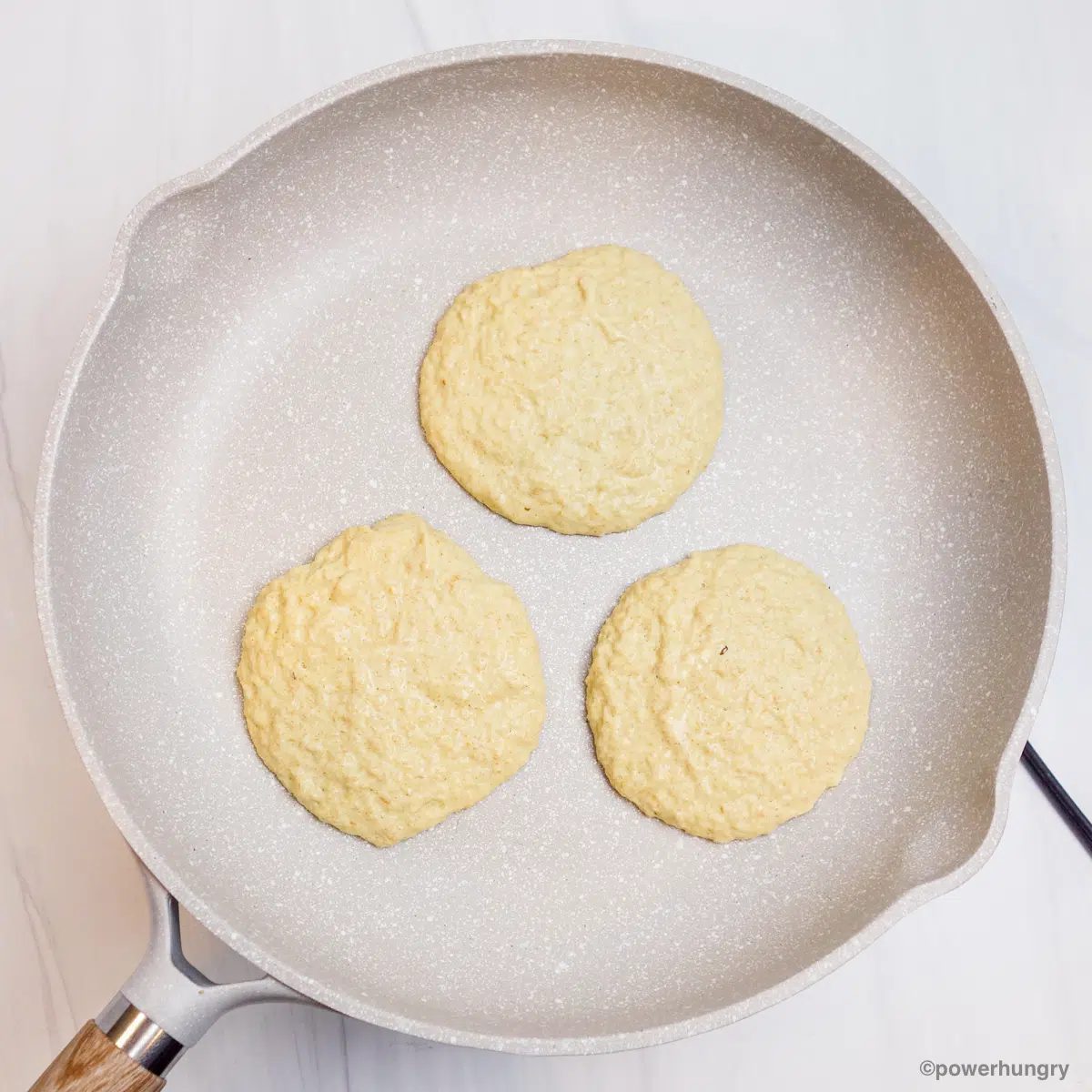 portions of millet pancake batter in a nonstick ceramic skillet