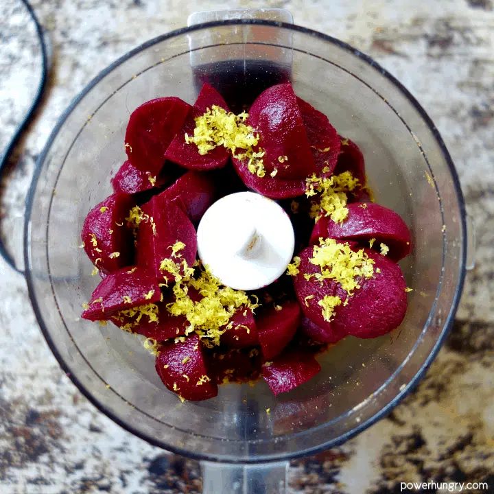 overhead shot of baby beets and lemon zest in a food processor bowl
