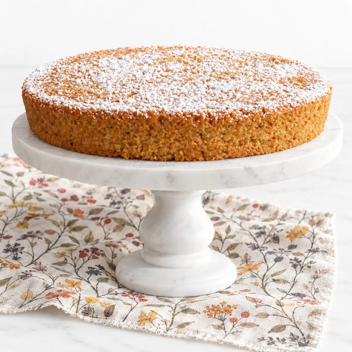 plain vegan almond flour cake on a cake stand