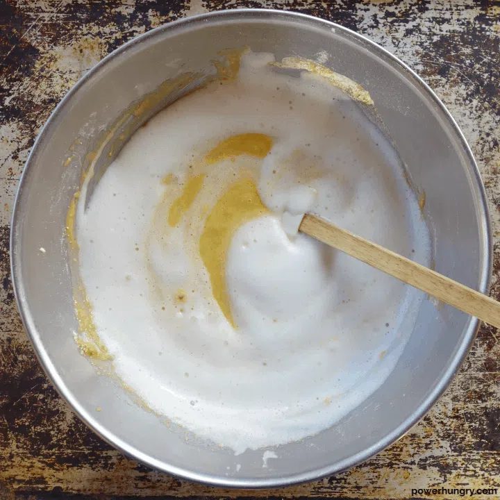 whipped aquafaba being added to vanilla cake batter