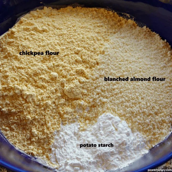 a dark blue bowl filled with chickpea flour, almond flour, and potato starch