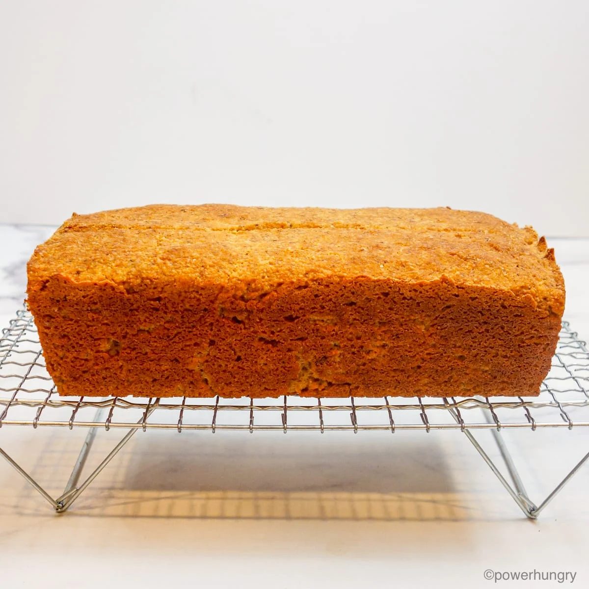 loaf of almond flour yeast bread on a wire cooling rack
