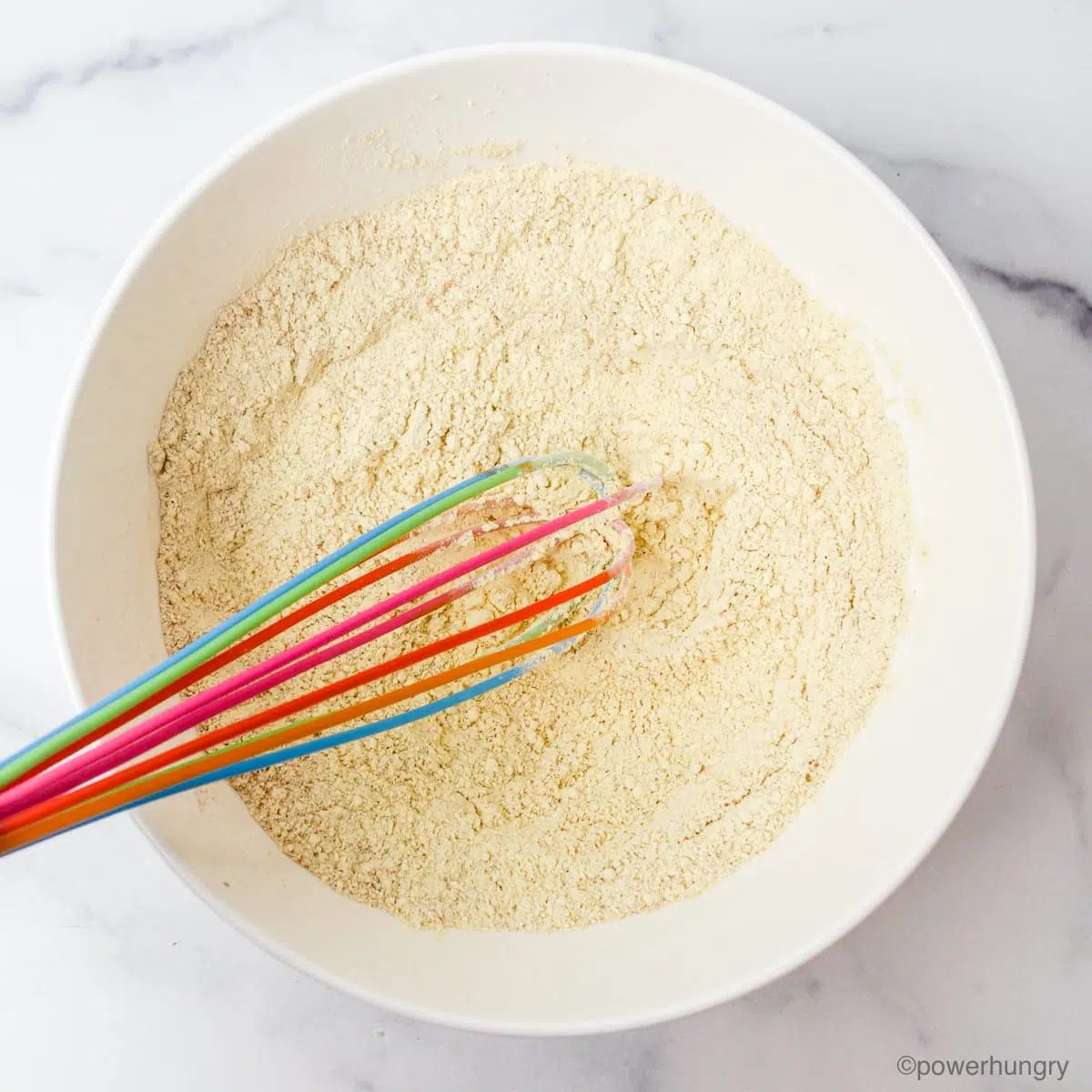 dry ingredients for almond flour sugar cookies in a white bowl