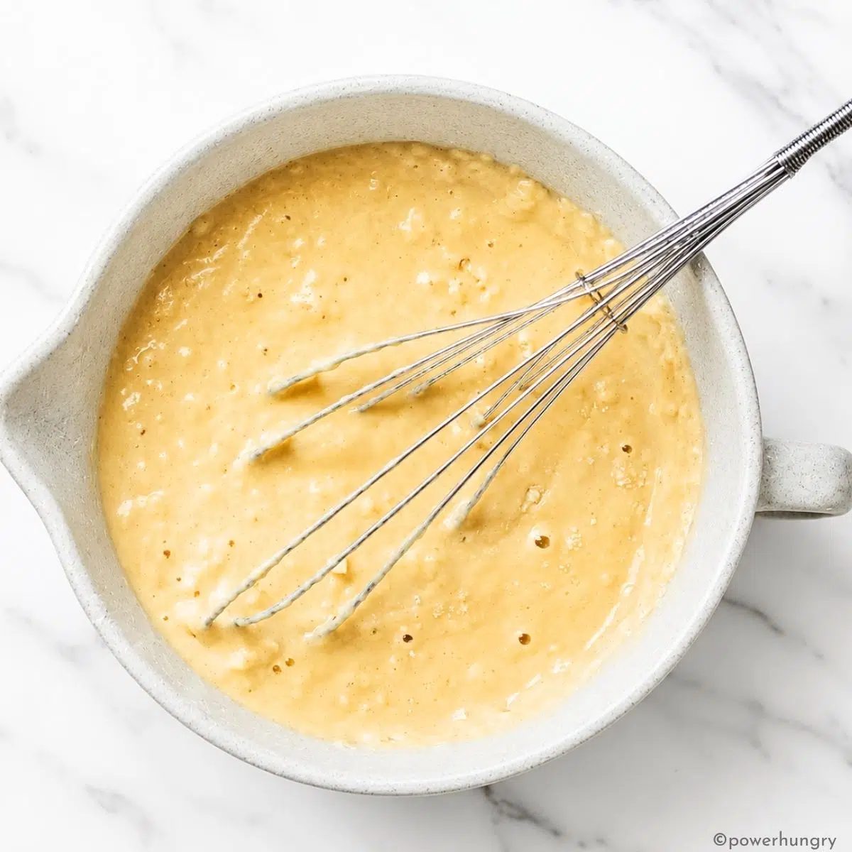 vegan almond flour waffle batter ina an off-white mixing bowl