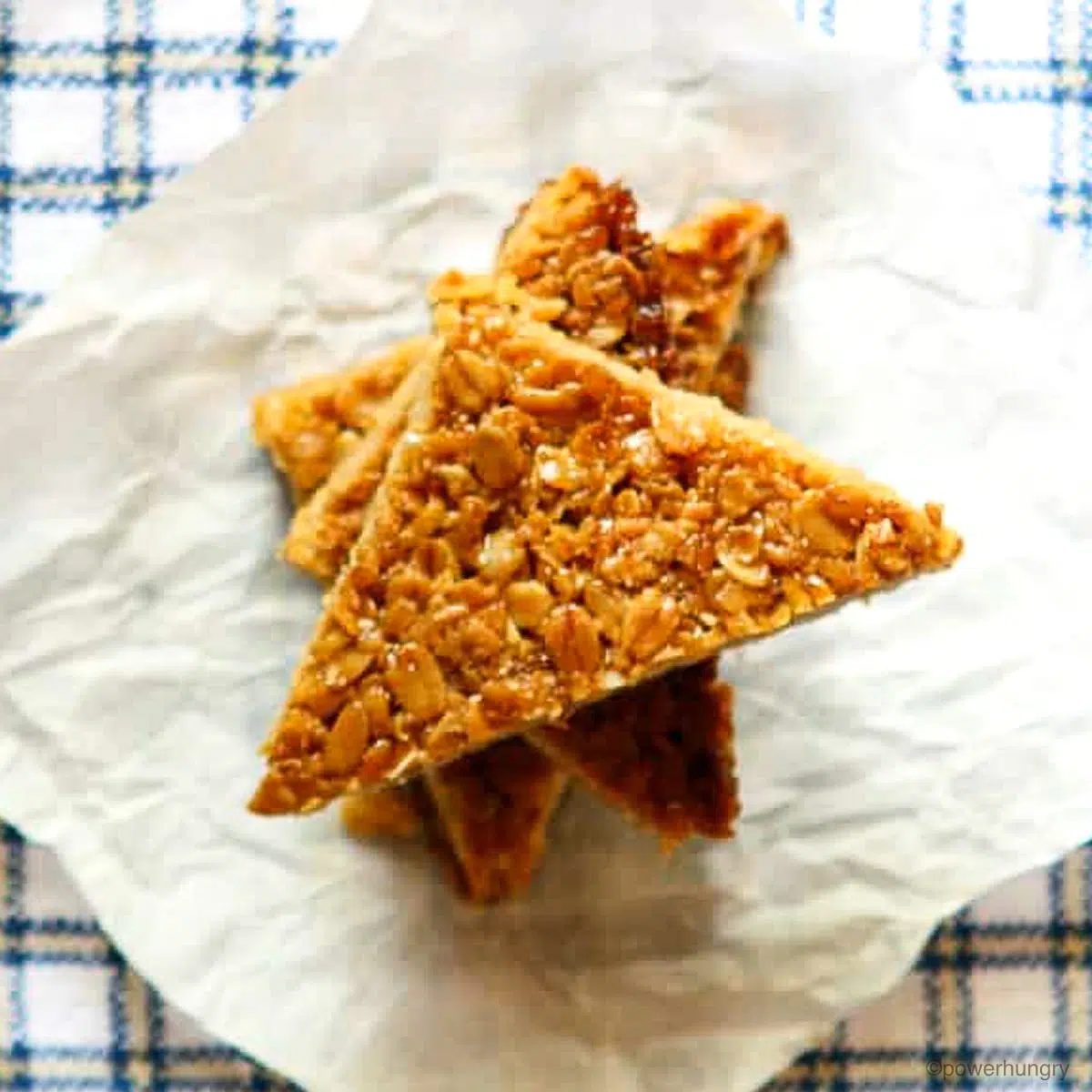 a stack of cut flapjacks atop a piece of parchment paper and a blue and white napkin
