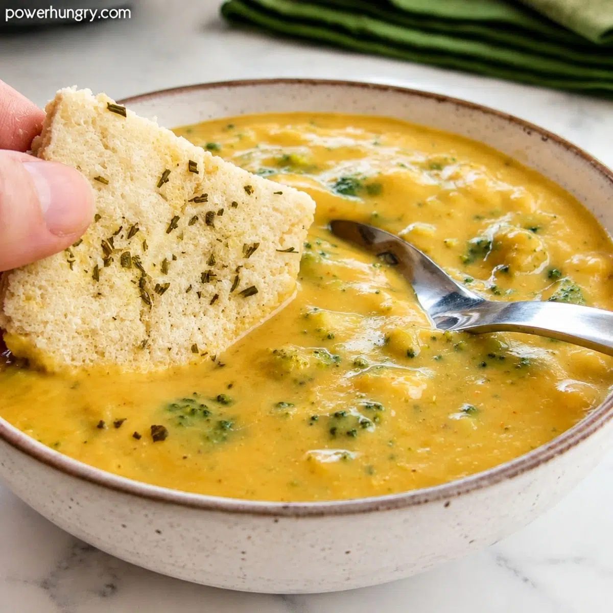 bowl of high protein broccoli cheese soup with crusty flatbread