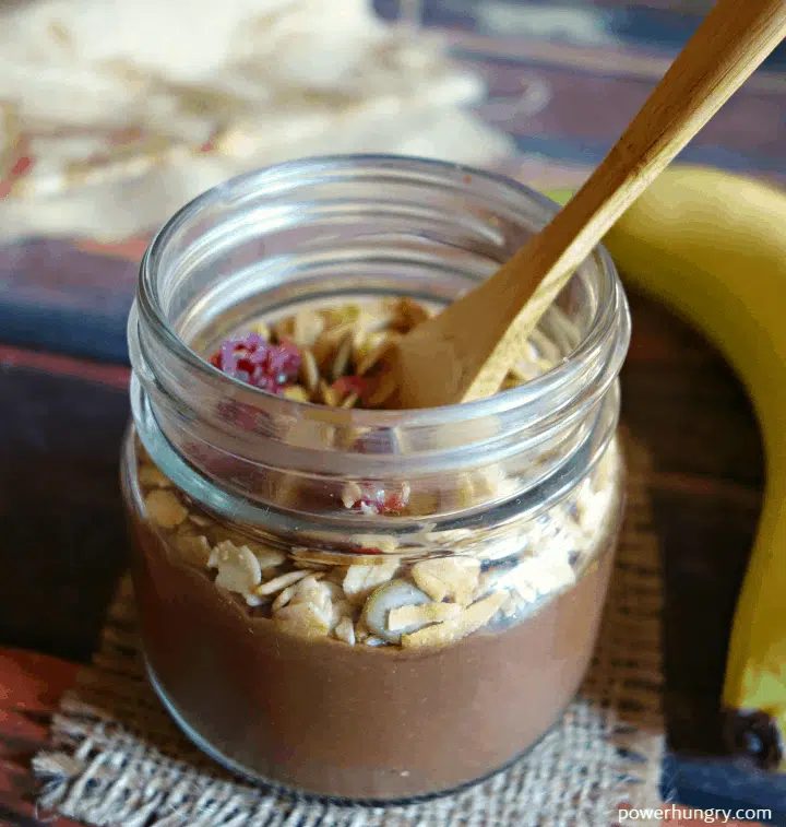 nourishing brownie batter breakfast oats in a jar, topped with some granola