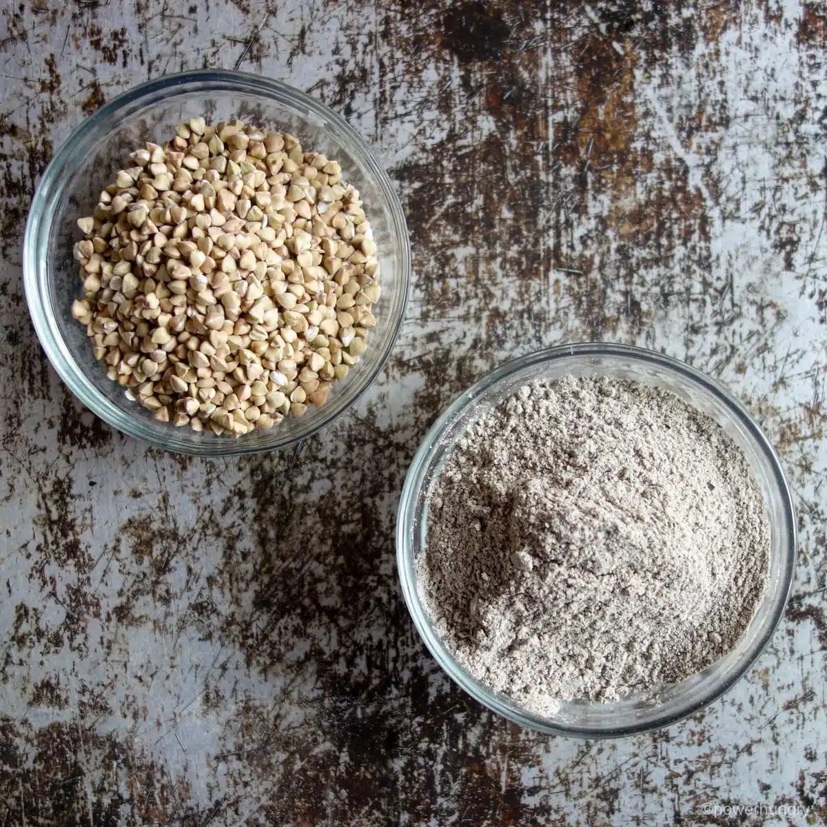 two bowls, one filled with buckwheat groats, the other with buckwheat flour