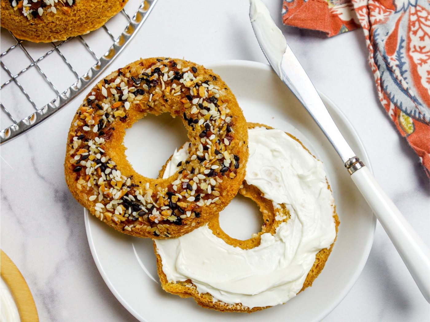 a sliced vegan chickpea flour bagel spread with vegan cashew cream cheese