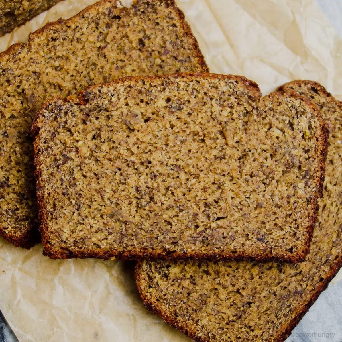 close up of slices of vegan chickpea flour banana bread on brown parchment paper