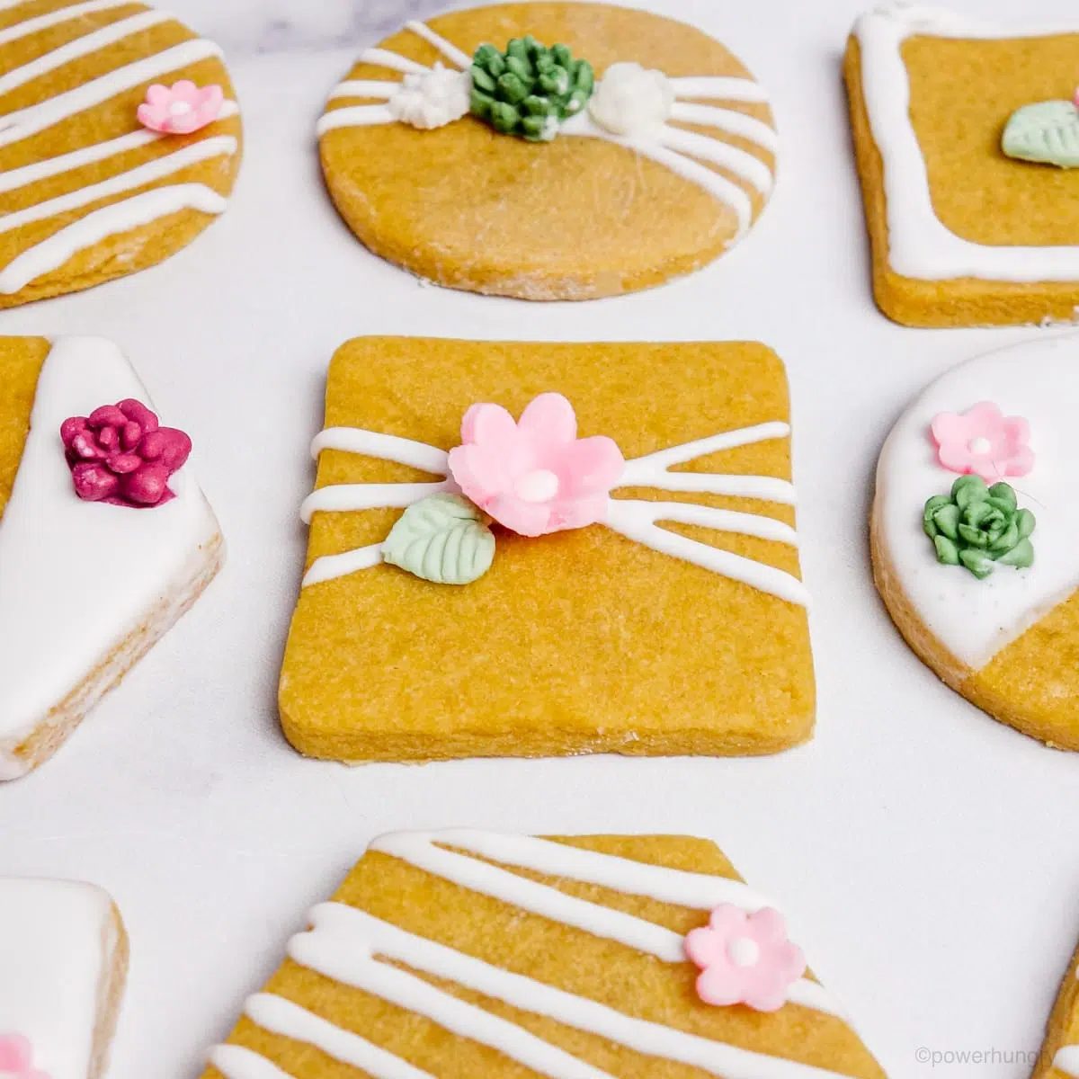 decorated vegan chickpea flour cut-out cookies on a marble surface