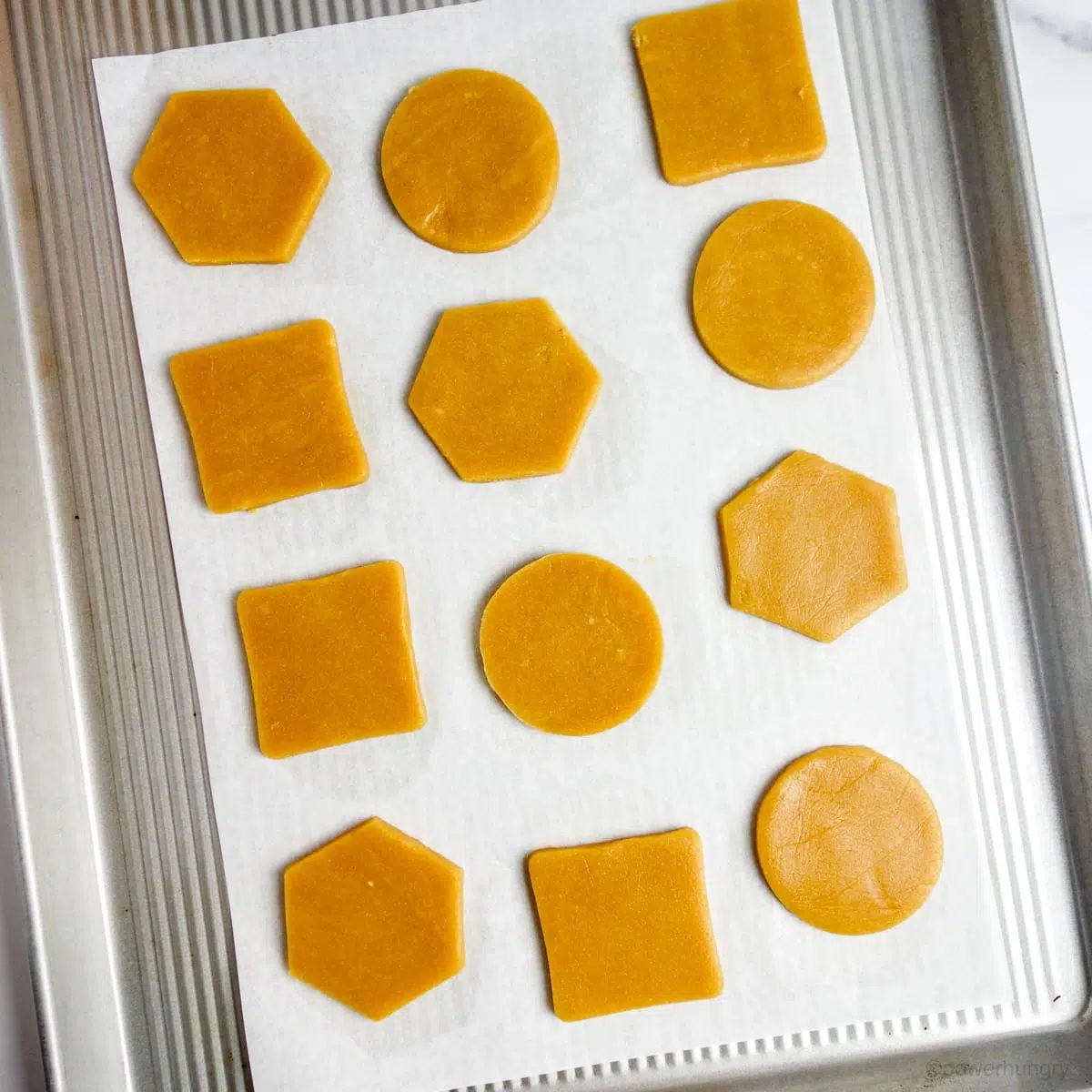 cookie dough shapes on a parchment lined baking sheet