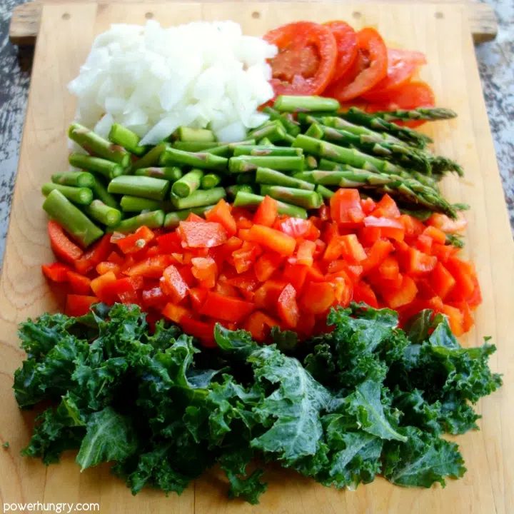 wooden cutting board with chopped raw vegetables