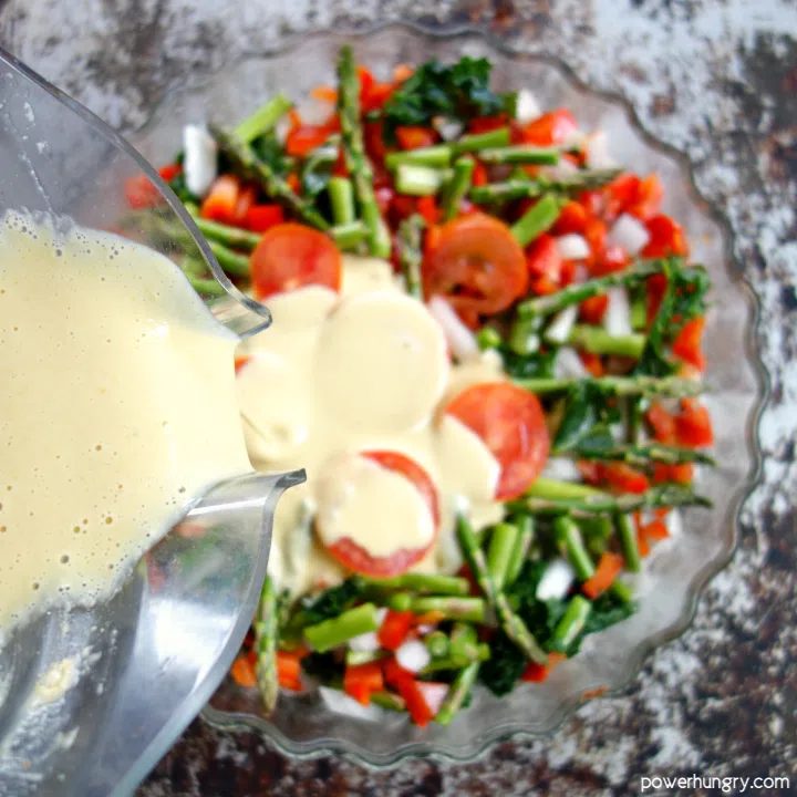 chickpea flour frittata batter being poured over vegetables in pan