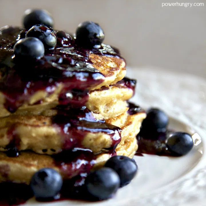 a stack of chickpea flour pancakes on a white plate, topped with blueberries