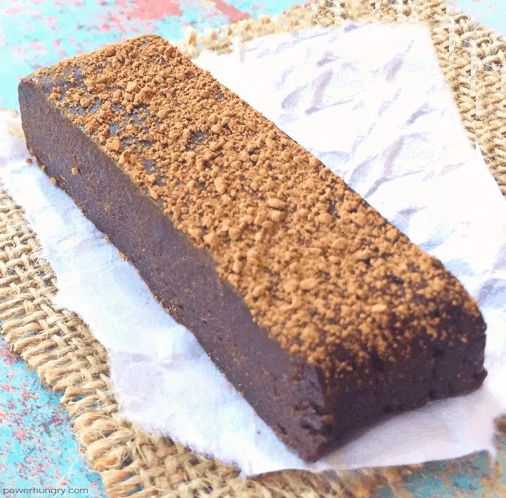 a single chocolate black bean protein bar on a piece of parchment paper