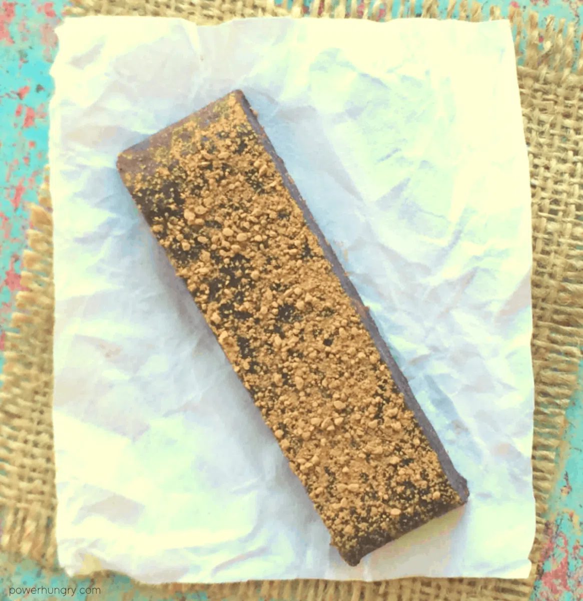 a single chocolate black bean protein bar on a piece of parchment paper