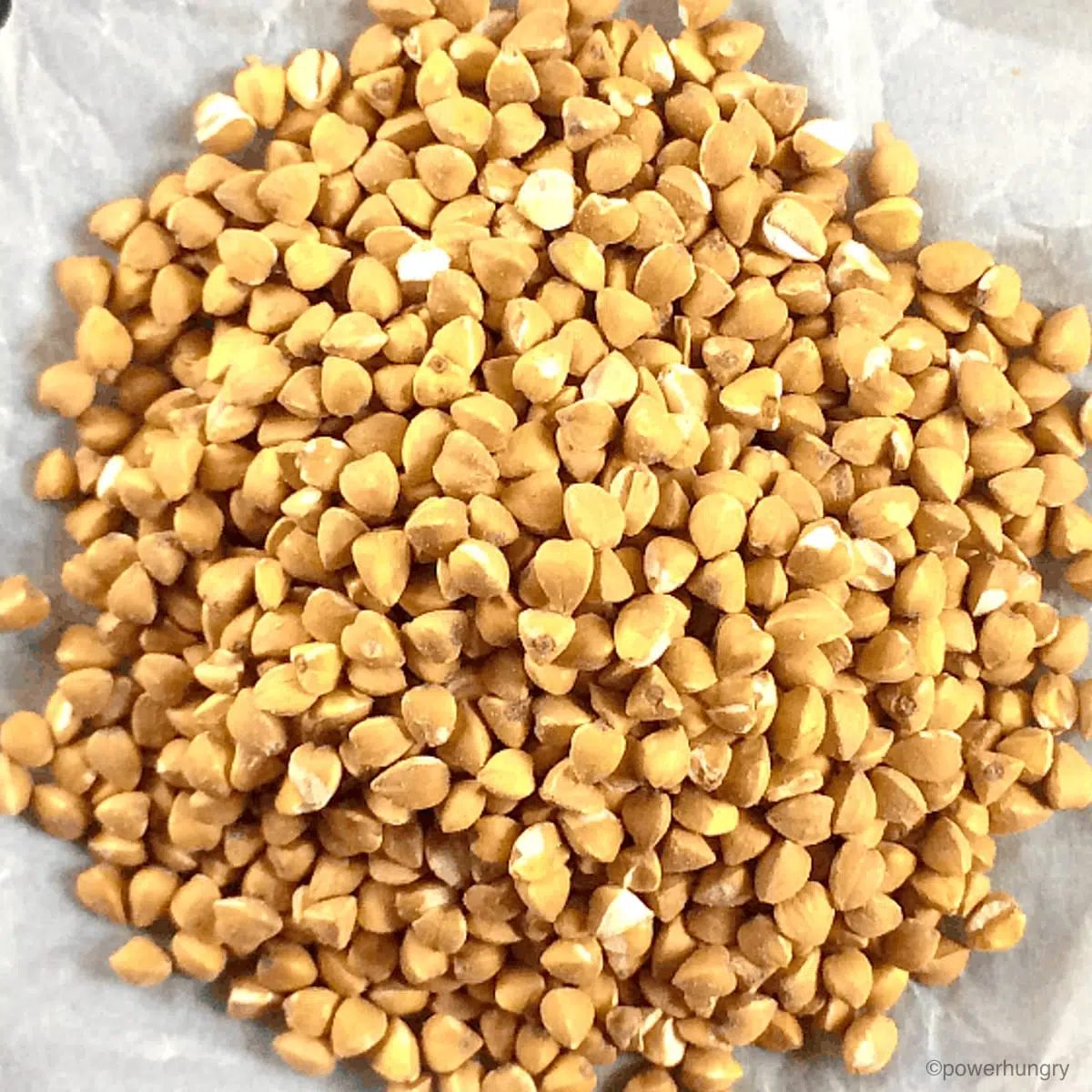 raw buckwheat groats on crumpled white parchment paper
