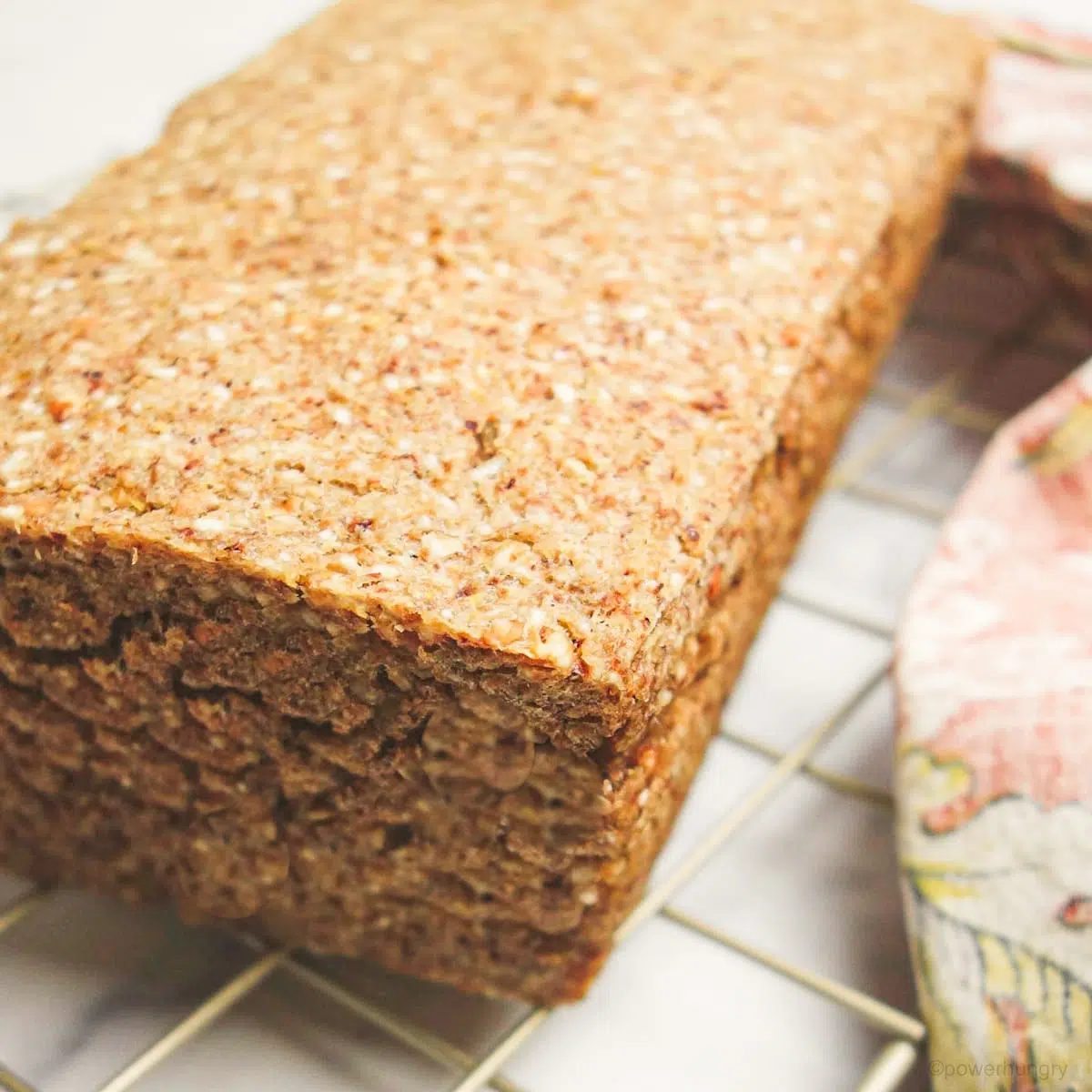 loaf of vegan cinnamon buckwheat bread on a gold cooling rack